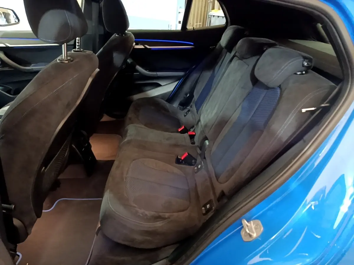 Vue intérieure côté droit sur la banquette arrière noire avec détails en tissu du BMW X2 bleu 2019.