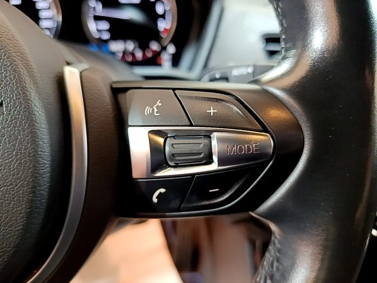 Gros plan sur les commandes multifonctions du volant noir d’une BMW X2 sDrive20i M Sport 2019.