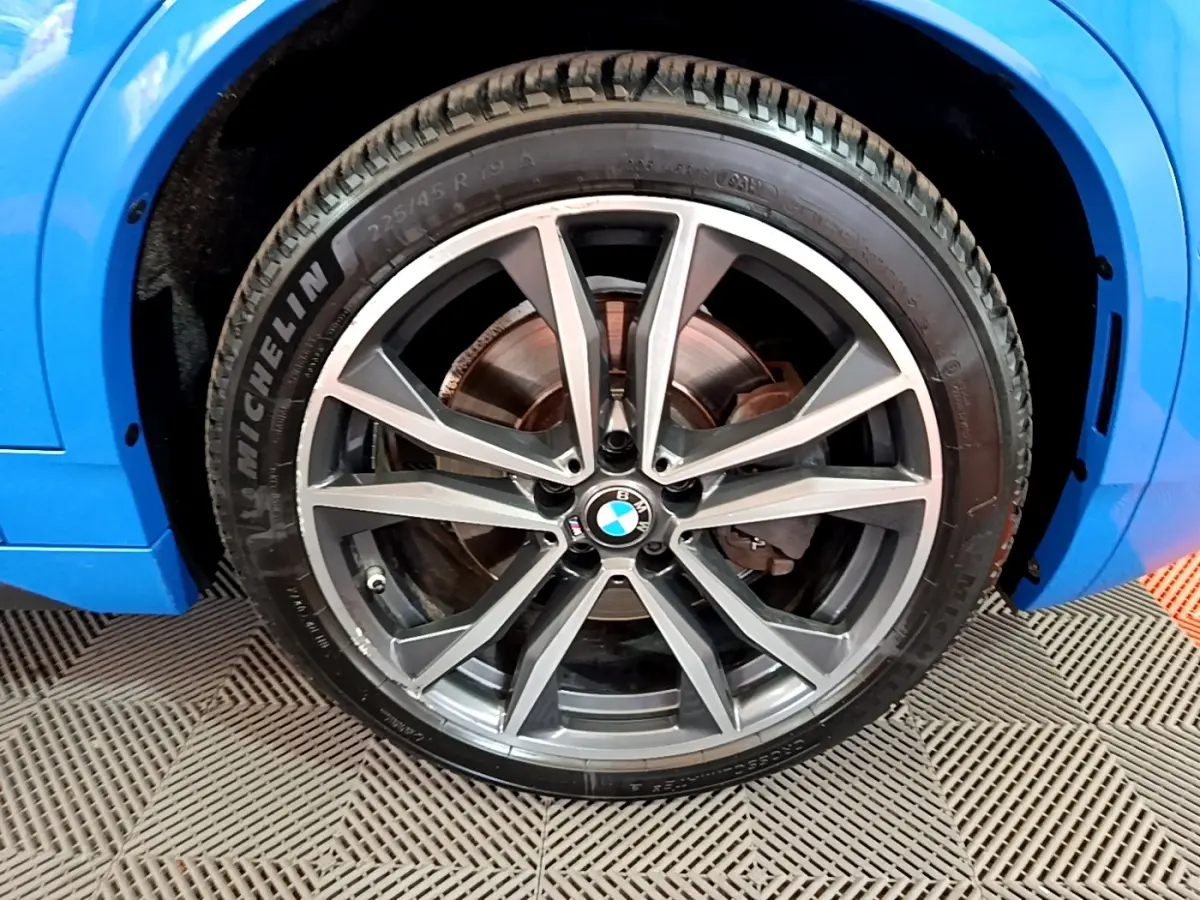 Gros plan sur la roue avant droite avec jante alliage BMW gris foncé du BMW X2 bleu sDrive20i M Sport 2019.