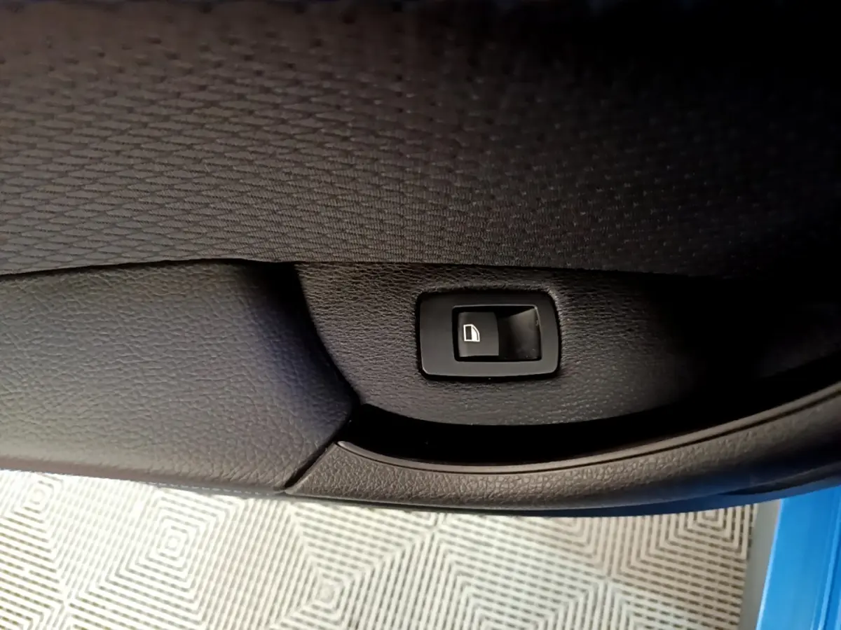 Détail de la commande de verrouillage sur la porte intérieure côté gauche d’un BMW X2 bleu 2019.