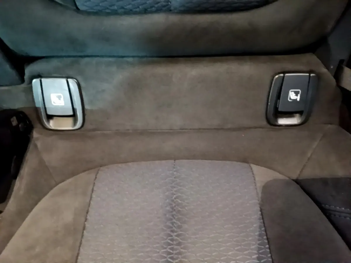 Détail des commandes de rabattement individuel des sièges arrière sur banquette tissu gris foncé de BMW X2 sDrive20i M Sport.