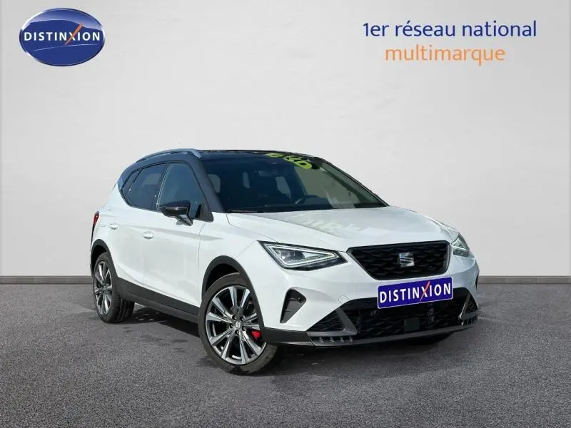 SEAT Arona 1.0 TSI 115ch FR blanc Candy avec toit noir Minuit, vue 3/4 avant mettant en valeur ses jantes et calandre noire.