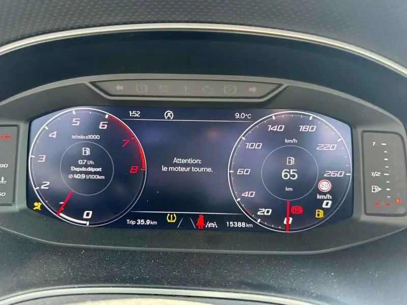 Tableau de bord numérique du SEAT Arona 2025 affichant 65 km/h, compte-tours et alertes, vue frontale rapprochée.