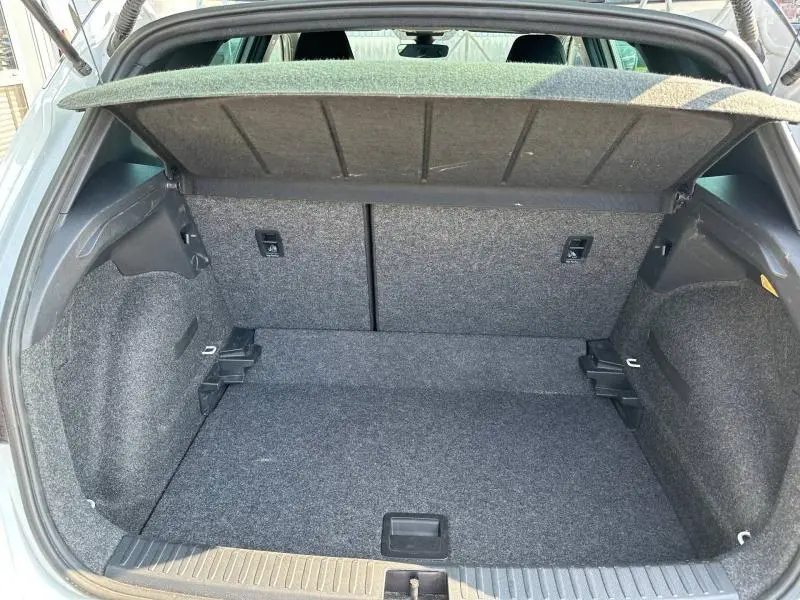 Coffre ouvert vu de l'arrière d'un SEAT Arona 1.0 TSI 115ch FR 2025, intérieur gris avec cache-bagages relevé.