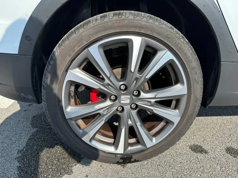 Gros plan sur la roue avant droite du SEAT Arona blanc Candy avec étrier de frein rouge et jante alliage grise.