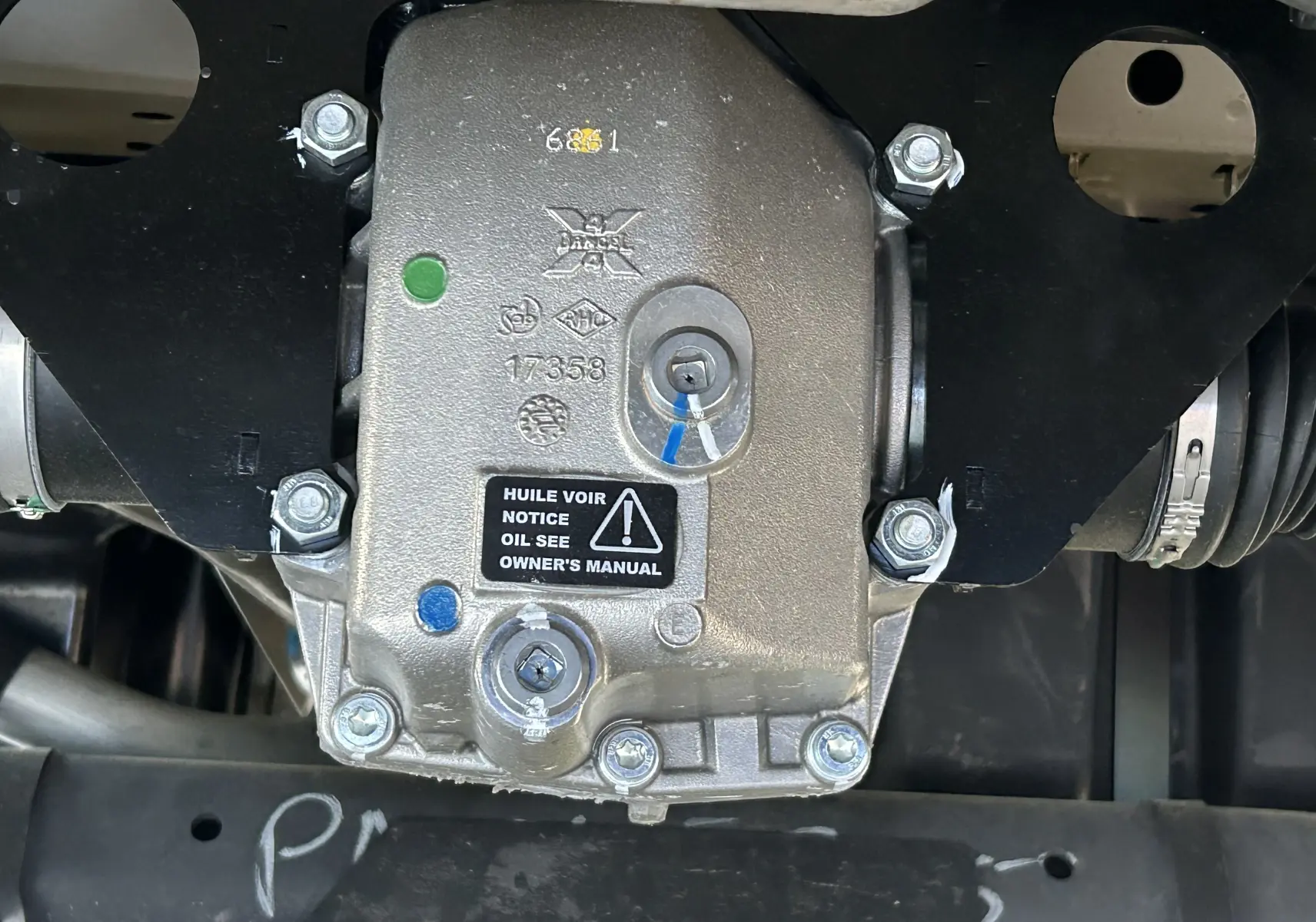 Gros plan sur le boîtier de transmission DANGEL du Peugeot Partner 4x4 gris Artense, montrant les fixations et étiquettes.