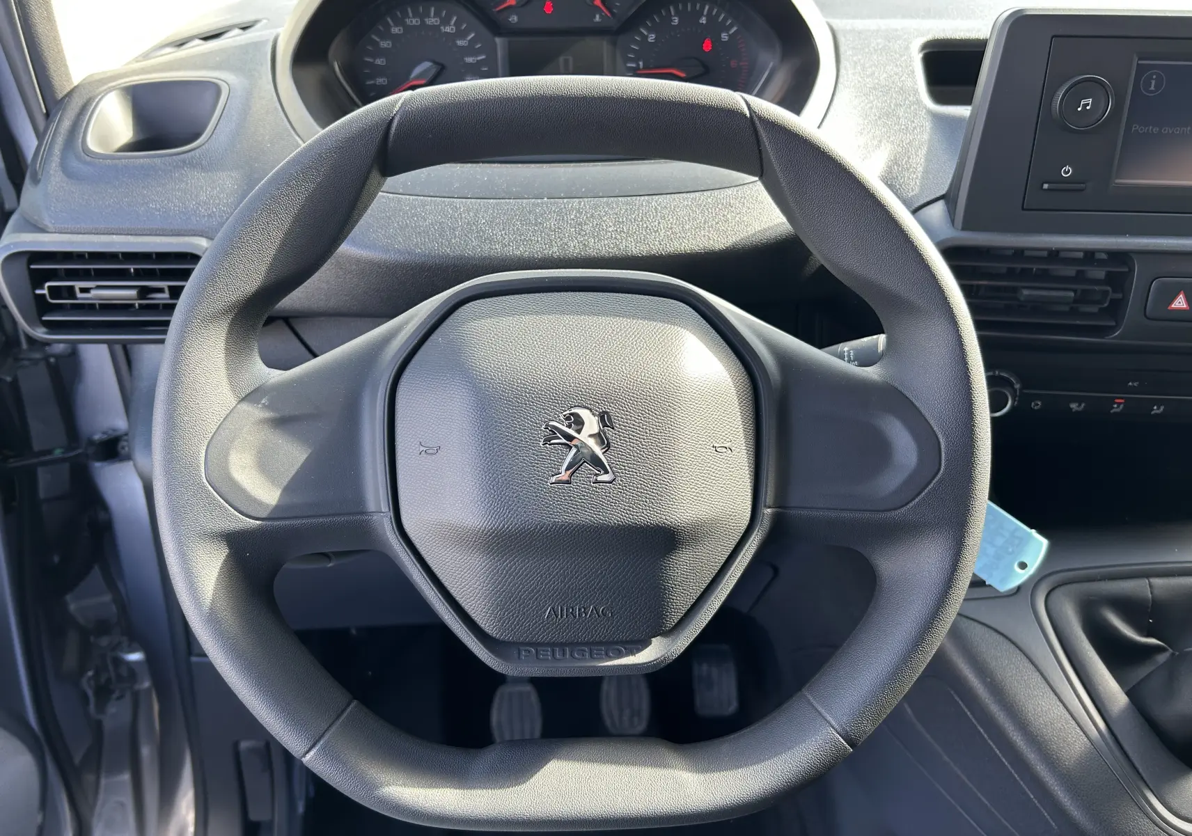 Vue rapprochée du volant Peugeot noir et du tableau de bord du DANGEL PARTNER 4x4 gris Artense de 2025.