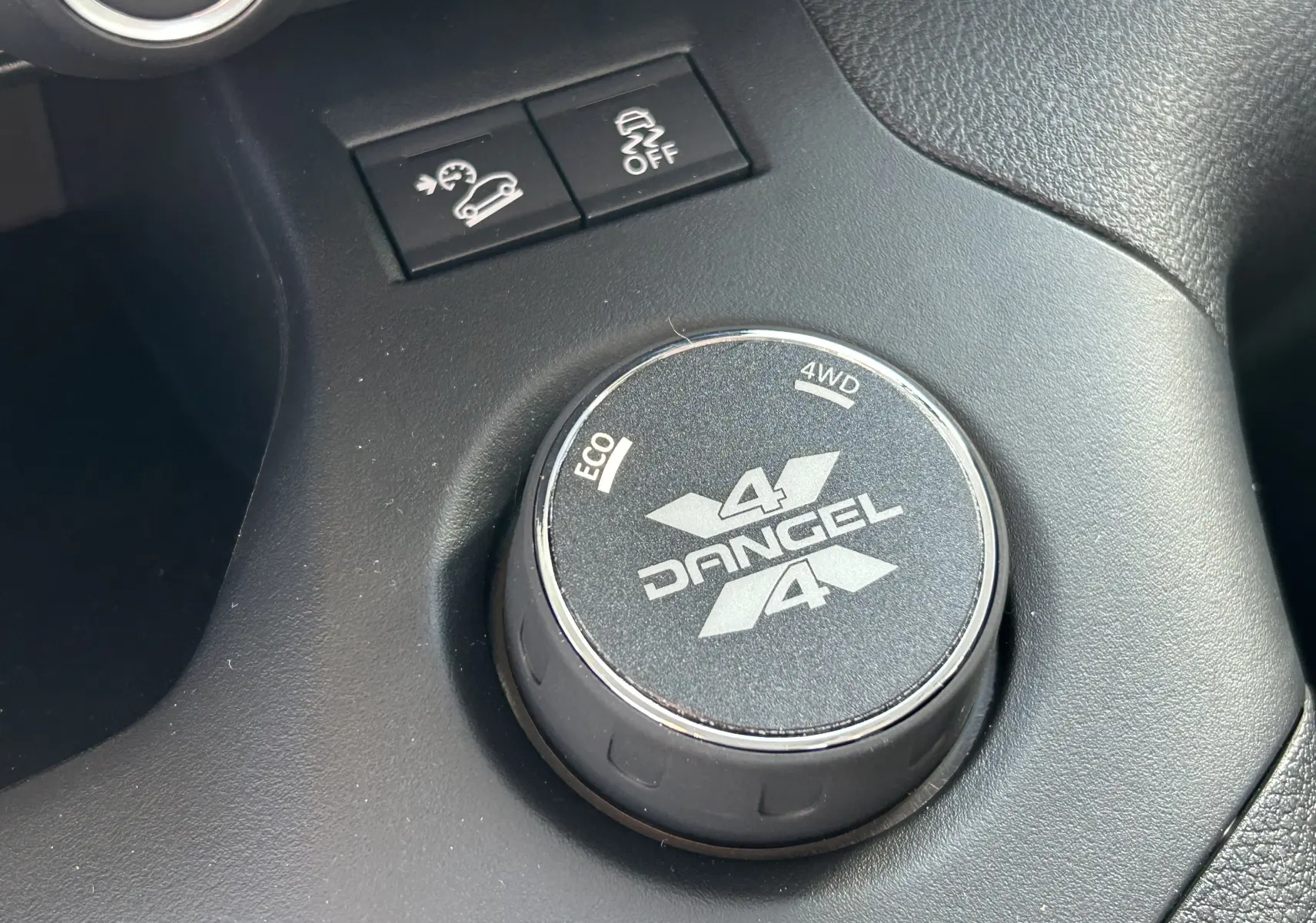 Gros plan sur le sélecteur rotatif 4x4 Dangel et boutons de contrôle dans l'habitacle noir du Partner gris Artense