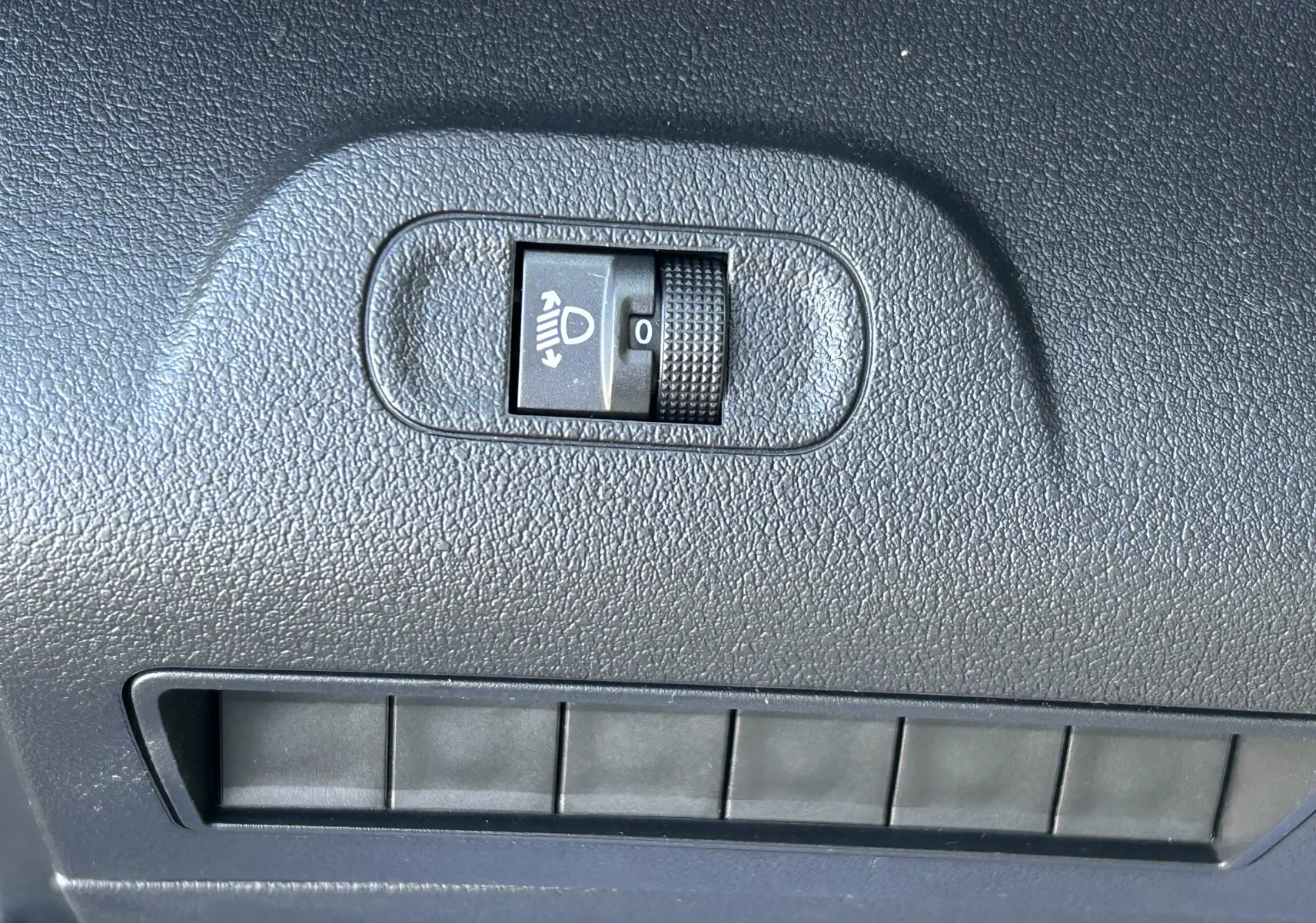 Molette de réglage de l'inclinaison des phares sur tableau de bord noir du DANGEL Partner gris Artense 2025.