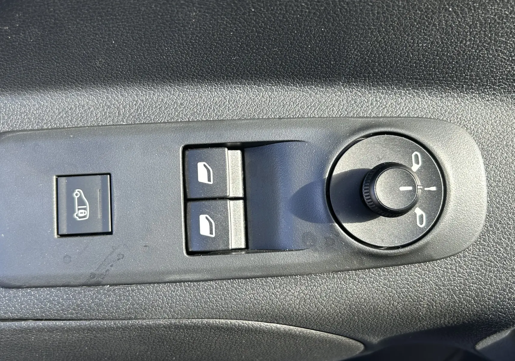 Panneau de commande des vitres et rétroviseurs sur la porte côté conducteur du DANGEL Partner gris Artense 2025.