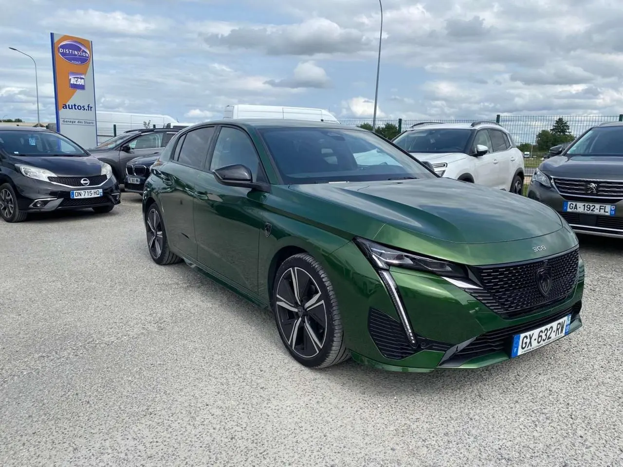 Peugeot 308 Vert Olivine vue 3/4 avant droit, avec calandre noire et feux LED en forme de griffes.