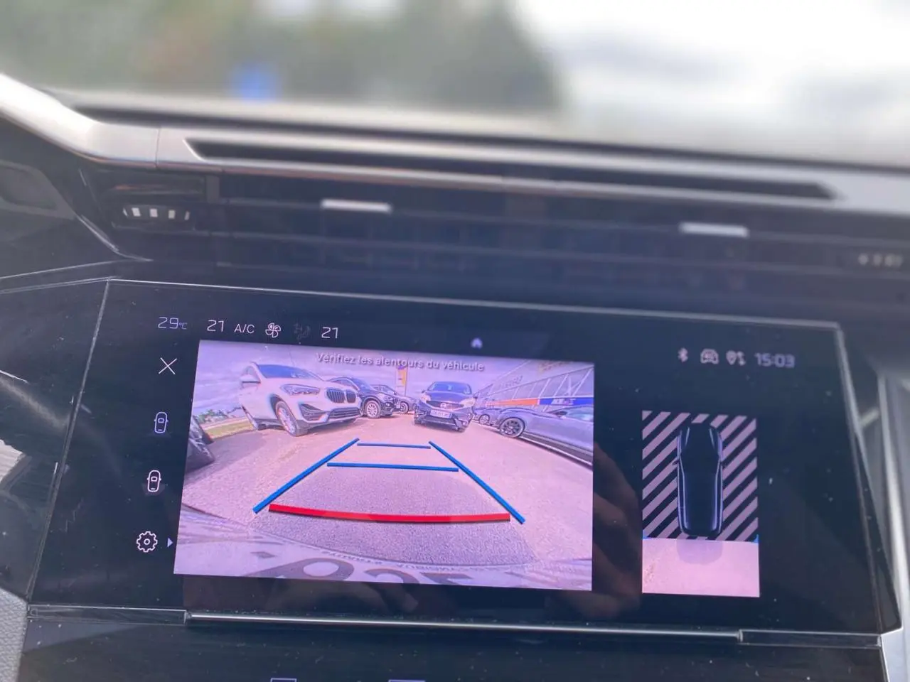 Écran central tactile de la Peugeot 308 2023 montrant la caméra de recul avec vue arrière et guidage de stationnement.