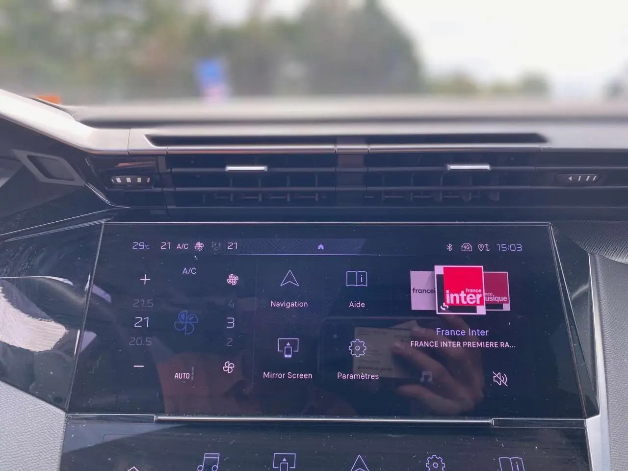 Écran tactile central du Peugeot 308 2023 affichant la navigation et la radio France Inter, vue de face intérieure.