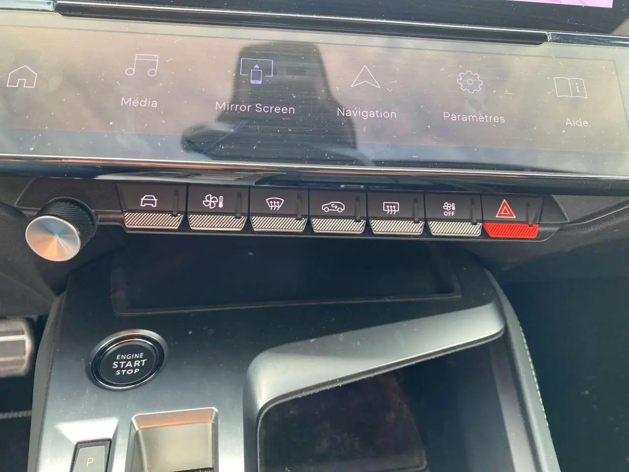 Gros plan sur la console centrale de la Peugeot 308 2023, montrant les commandes tactiles et le bouton start/stop.