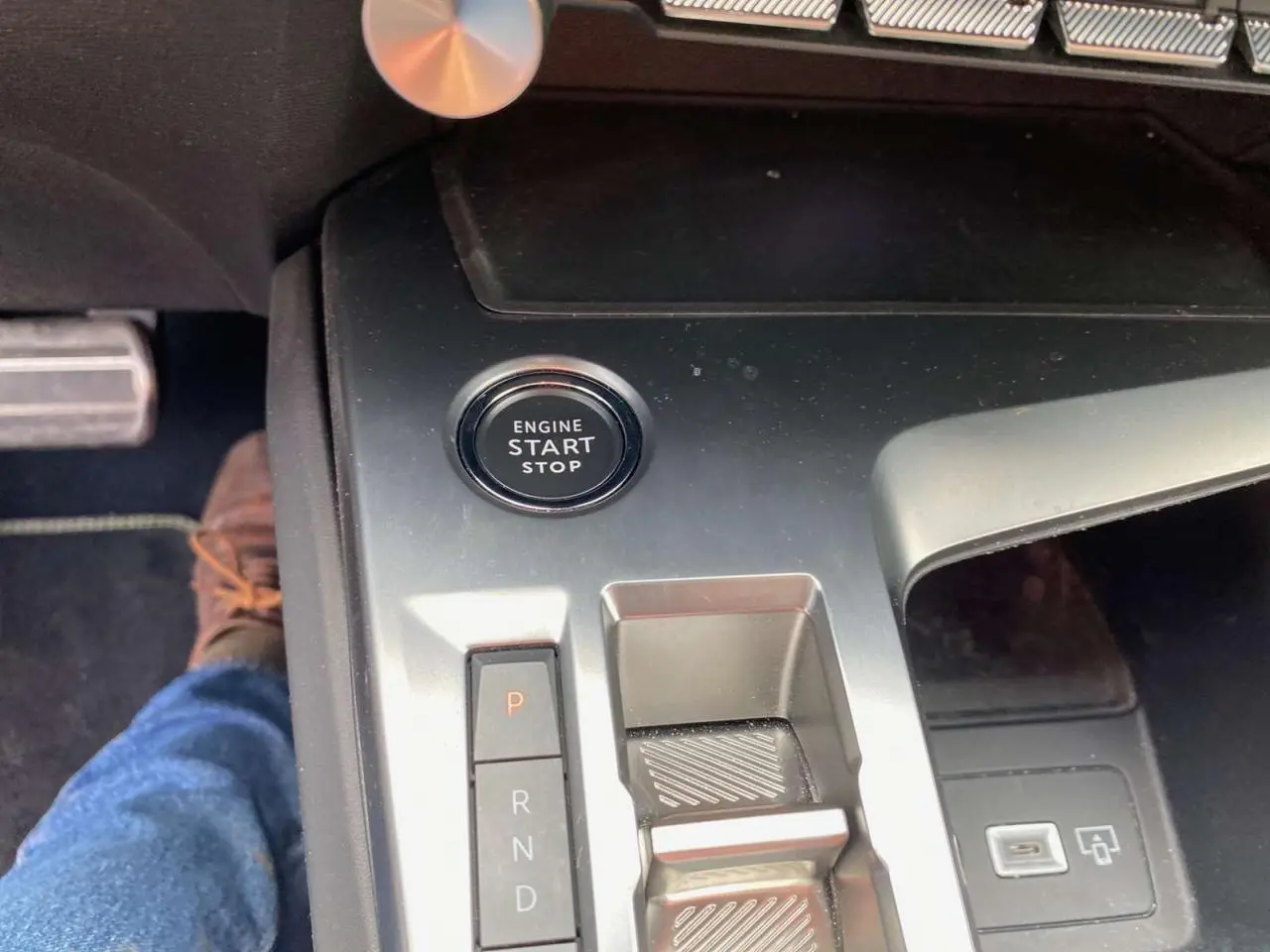 Gros plan sur la console centrale de la Peugeot 308 2023 avec bouton start/stop et levier de boîte automatique.