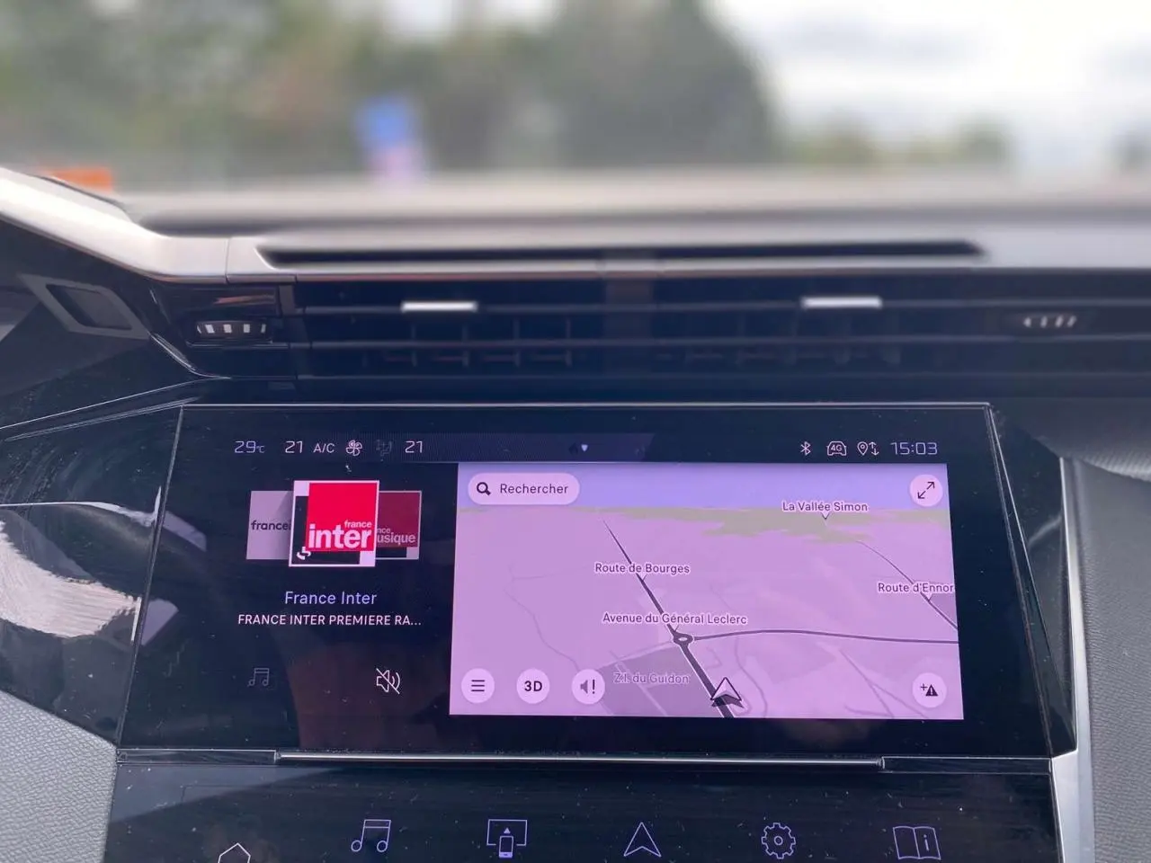 Écran tactile central de la Peugeot 308 2023 affichant navigation et radio France Inter, vue intérieure du tableau de bord.