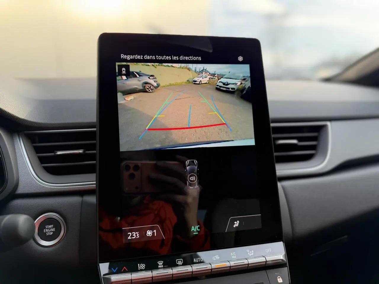 Écran tactile central montrant la caméra de recul du Renault Captur blanc nacré, intérieur avec tableau de bord noir.