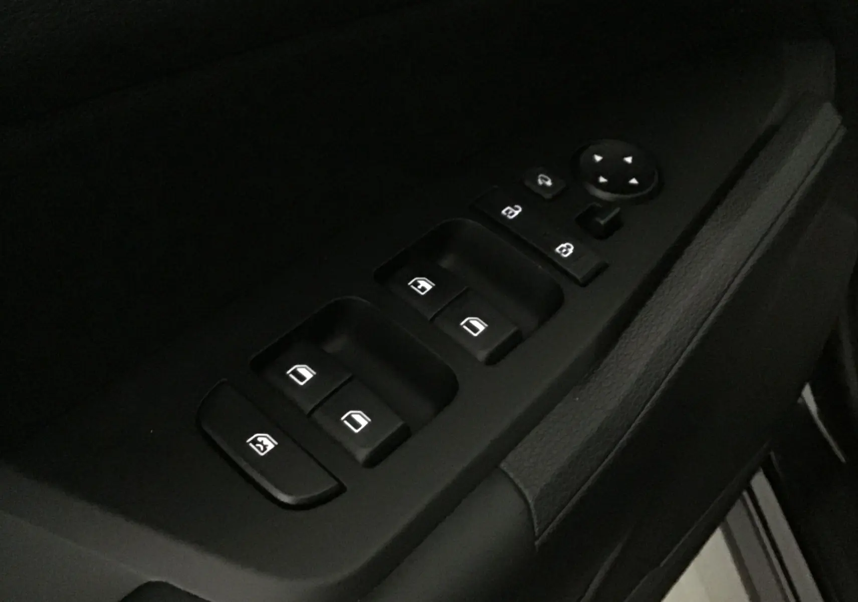 Gros plan sur les commandes des vitres et rétroviseurs côté gauche du Kia Sportage 2025, intérieur noir.