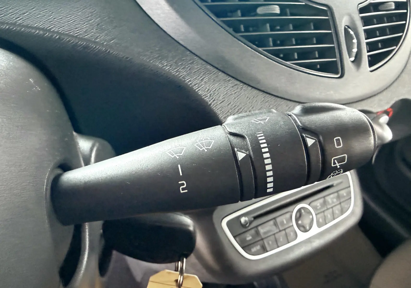 Gros plan sur la commande d’essuie-glace côté gauche du tableau de bord gris de la Renault Twingo II.