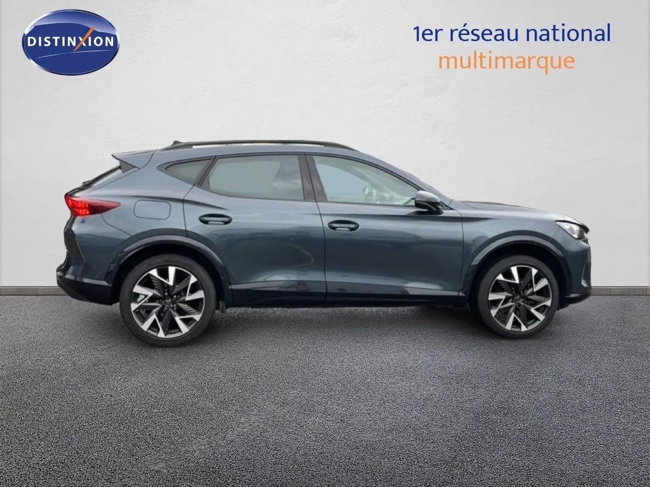 Vue de profil côté gauche d'un CUPRA Formentor 2025 gris magnétique métallisé avec jantes alliage bicolores.