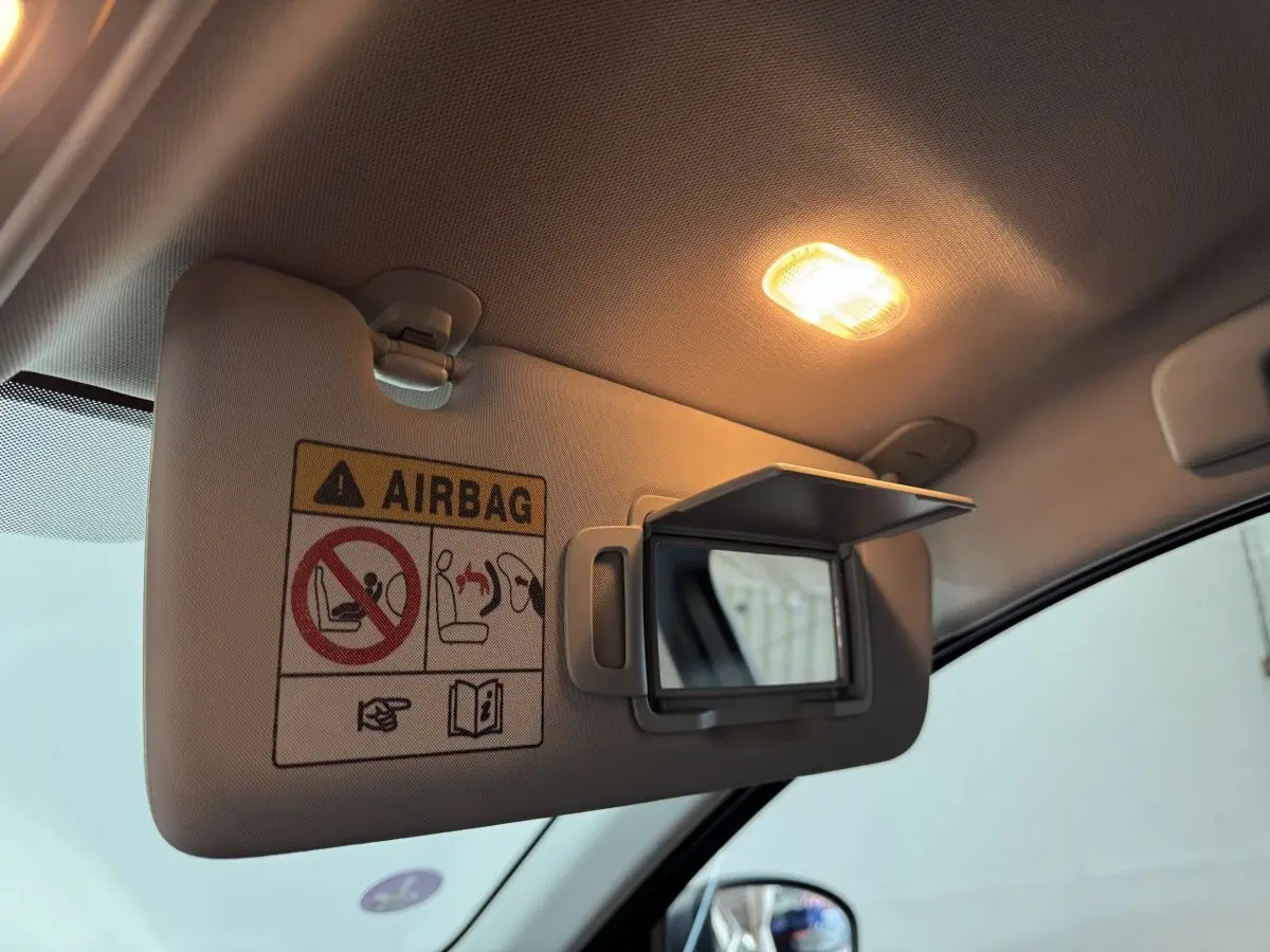 Détail du pare-soleil côté conducteur avec miroir et avertissement airbag dans un Renault Arkana gris foncé 2022.