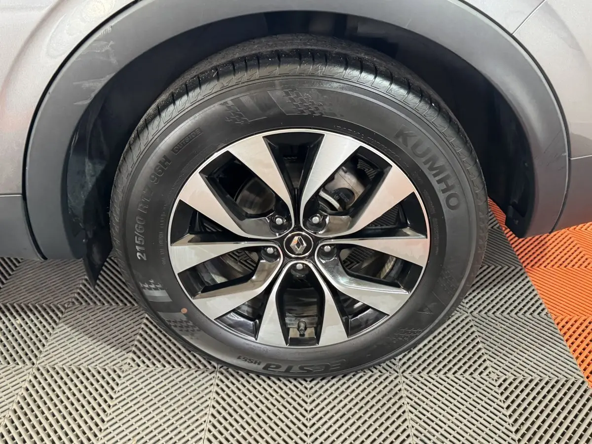 Gros plan sur la roue avant droite avec jante alliage bicolore du Renault Arkana gris foncé Business E-TECH 145.