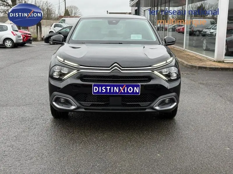 Vue de face d'une Citroën C4 X 2024 noire Perla Nera avec signature lumineuse distinctive et calandre large.
