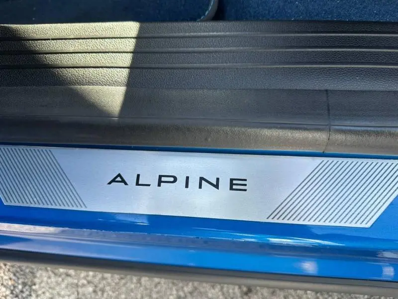 Détail de la plaque de seuil de porte ALPINE sur une Renault Rafale bleu sommet métallisé.