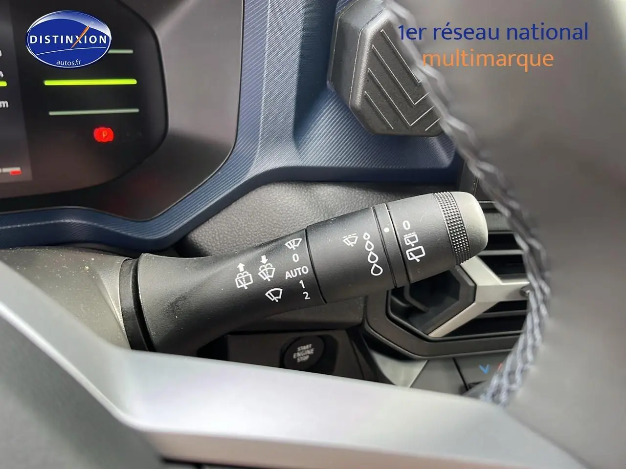 Gros plan sur la commande des essuie-glaces du Dacia Duster gris schiste, avec tableau de bord et aérateurs visibles.