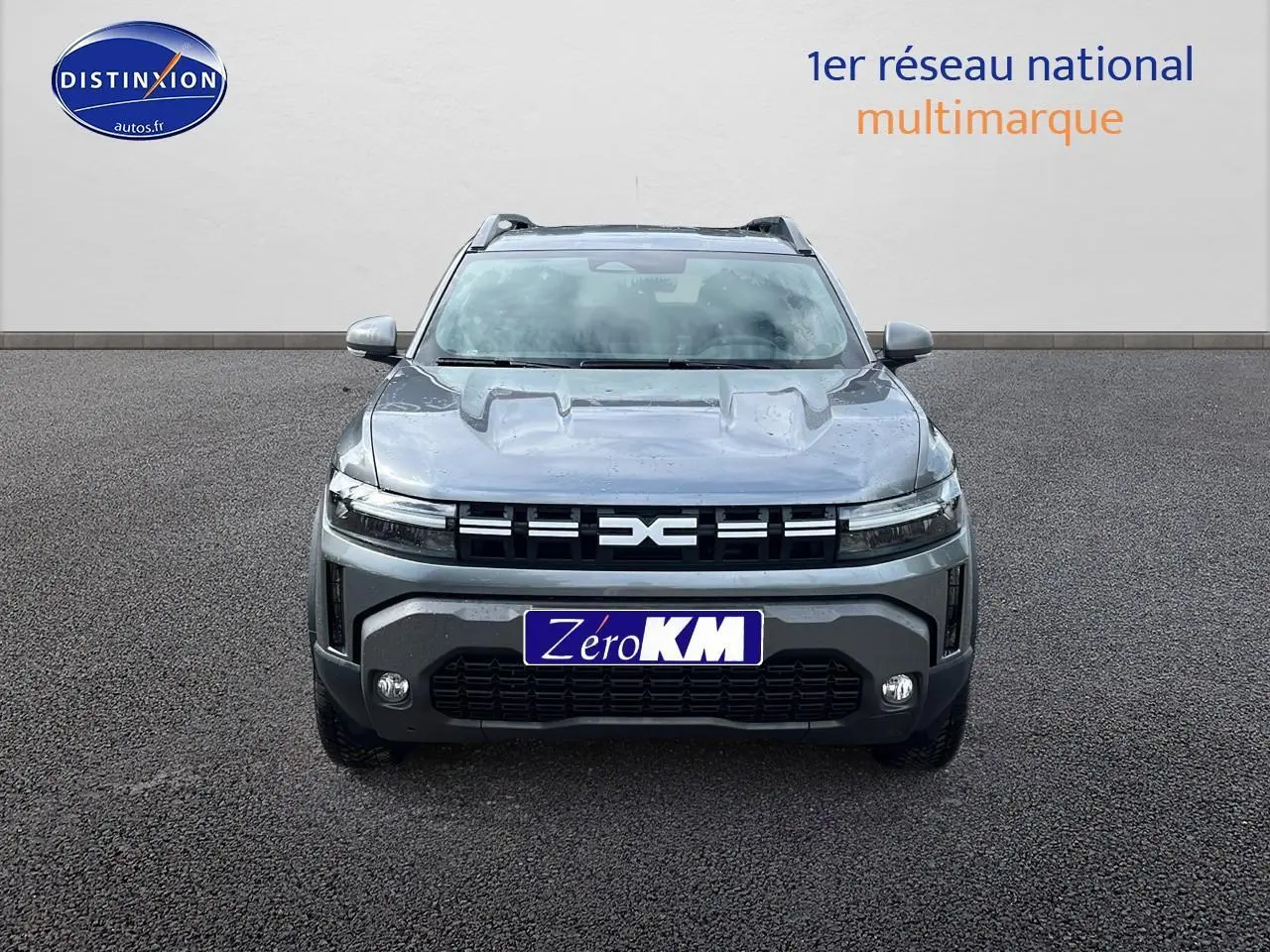 Vue frontale d'un Dacia Duster 2025 gris schiste avec calandre noire et phares LED fins.
