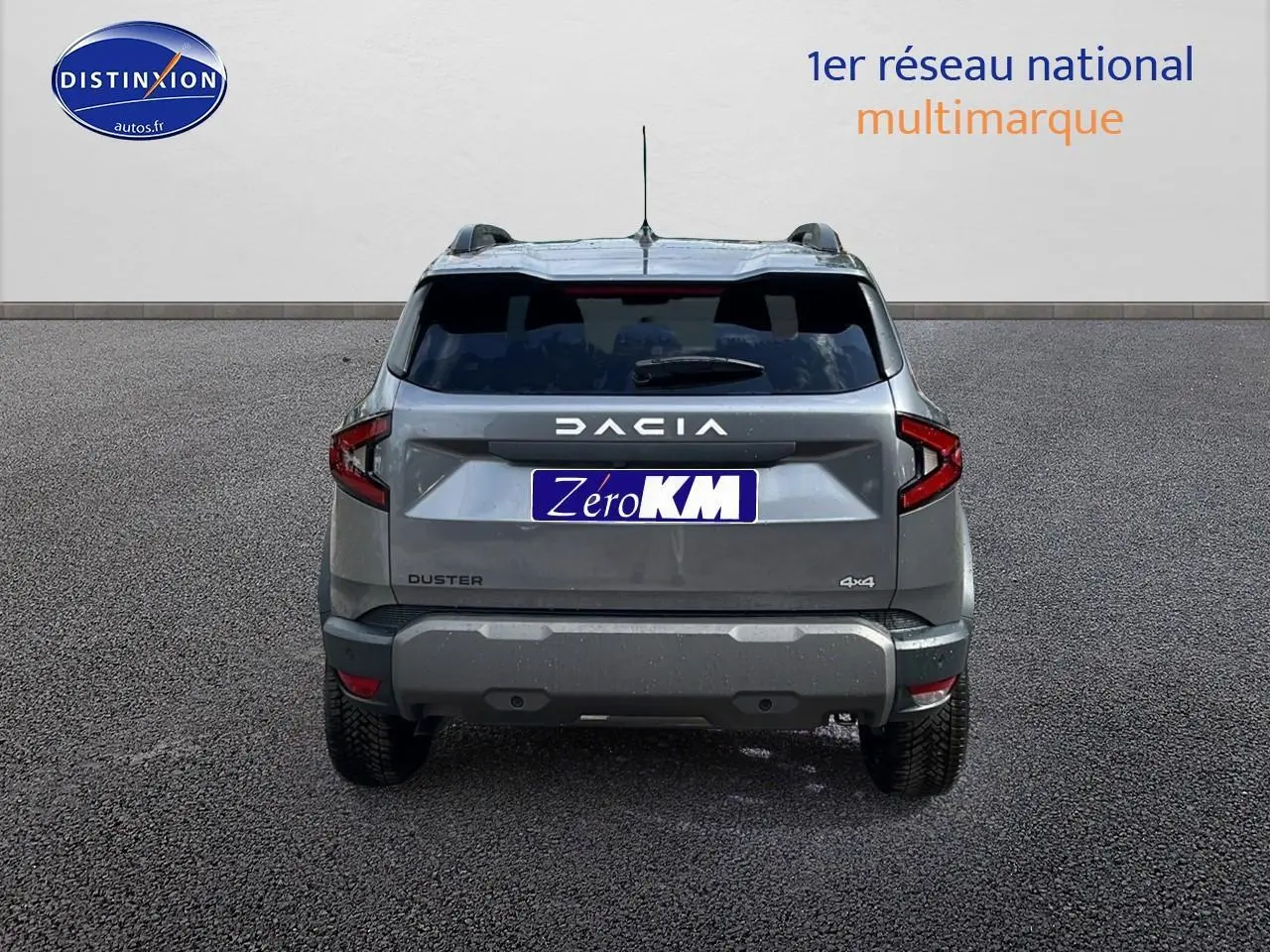 Vue arrière du Dacia Duster gris schiste 2025 avec logo DACIA et plaques Zero KM visibles sur un sol goudronné.