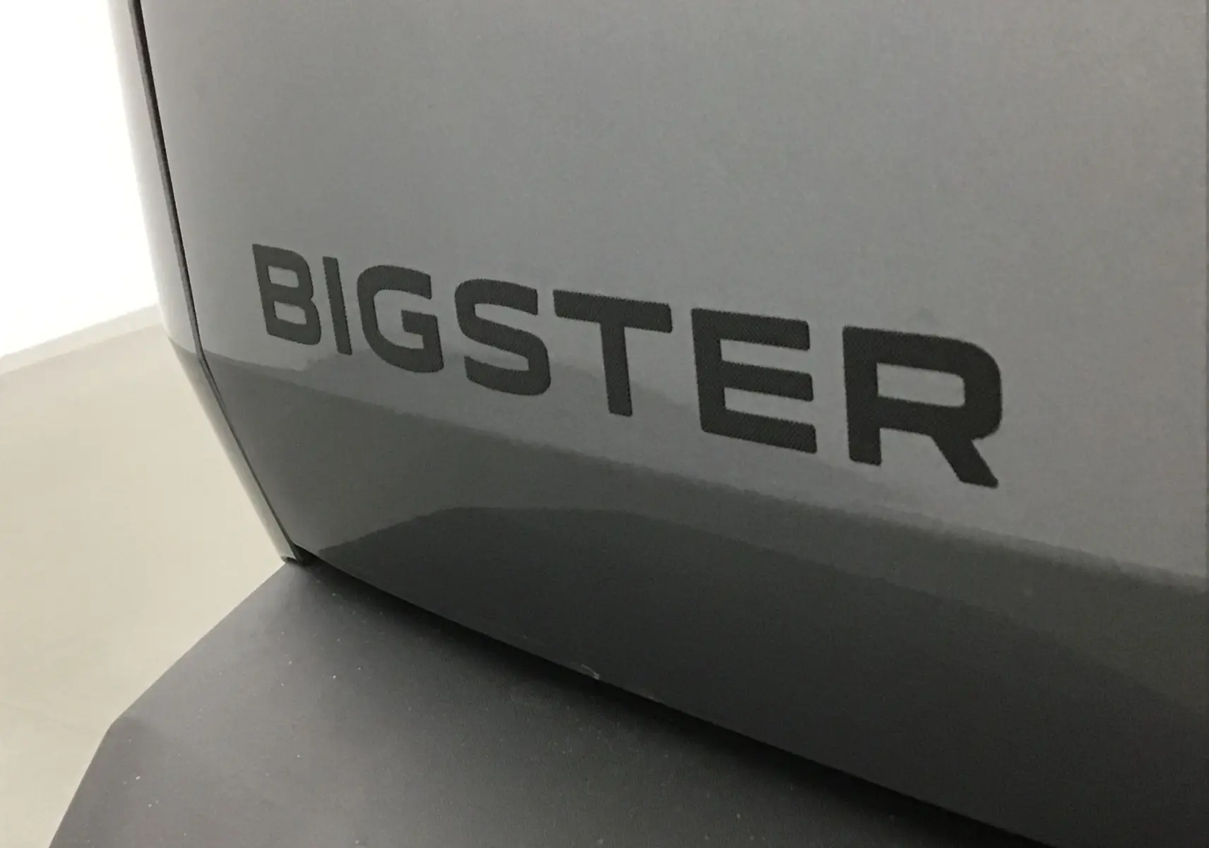 Gros plan sur l'inscription BIGSTER en noir sur la carrosserie gris schiste du Dacia Bigster 2025.
