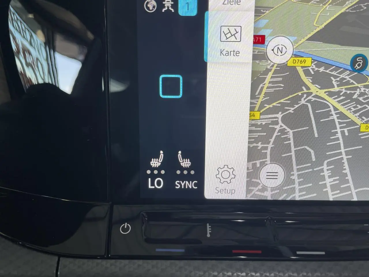 Écran tactile du système de navigation et climatisation digitale de la Volkswagen Golf rouge métal, vue intérieure rapprochée.