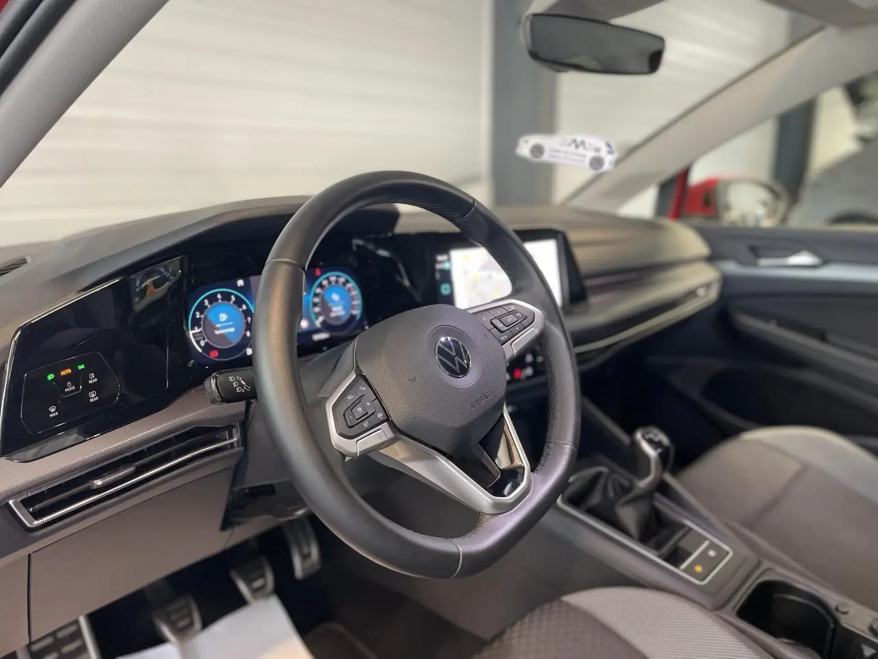 Intérieur de la Volkswagen Golf 1.5 TSI 2022, vue du volant cuir multifonction et tableau de bord digital.