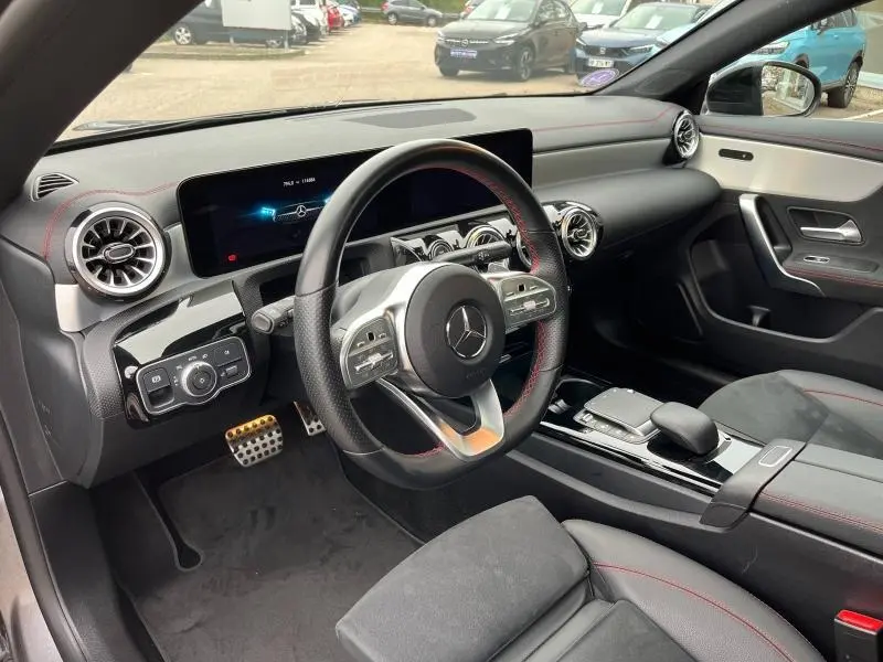 Intérieur noir avec surpiqûres rouges de la Mercedes CLA Shooting Brake 250 AMG Line, vue côté conducteur.