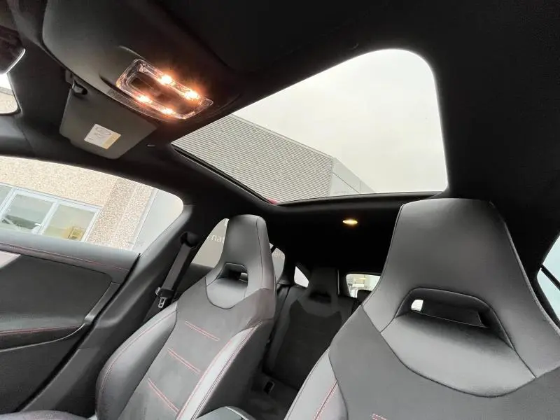 Intérieur de la Mercedes CLA Shooting Brake AMG Line 250 gris montagne, vue sur sièges sport et toit ouvrant panoramique.