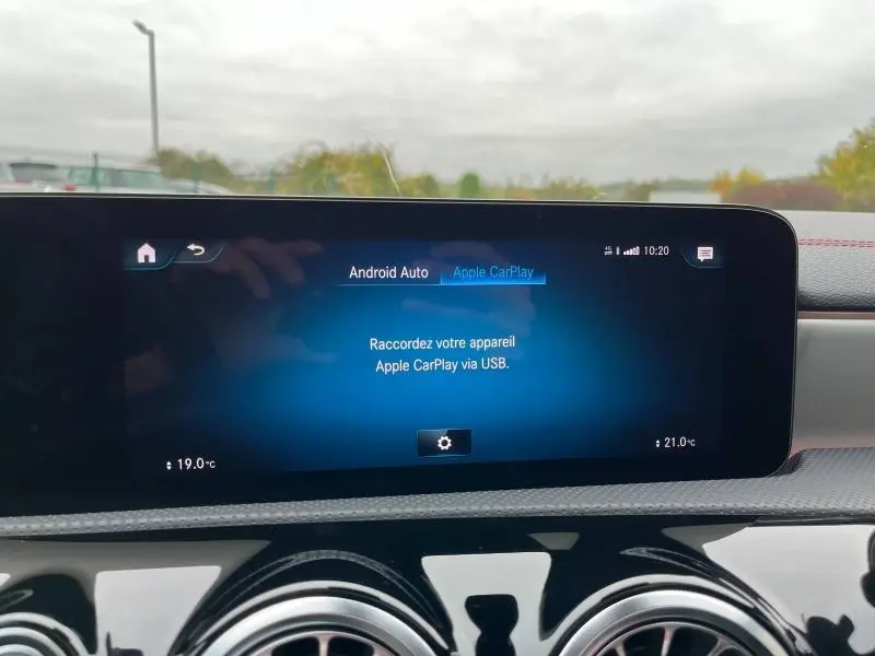 Écran tactile central du système MBUX dans une Mercedes CLA Shooting Brake 250 AMG Line gris montagne, affichant Apple CarPlay.