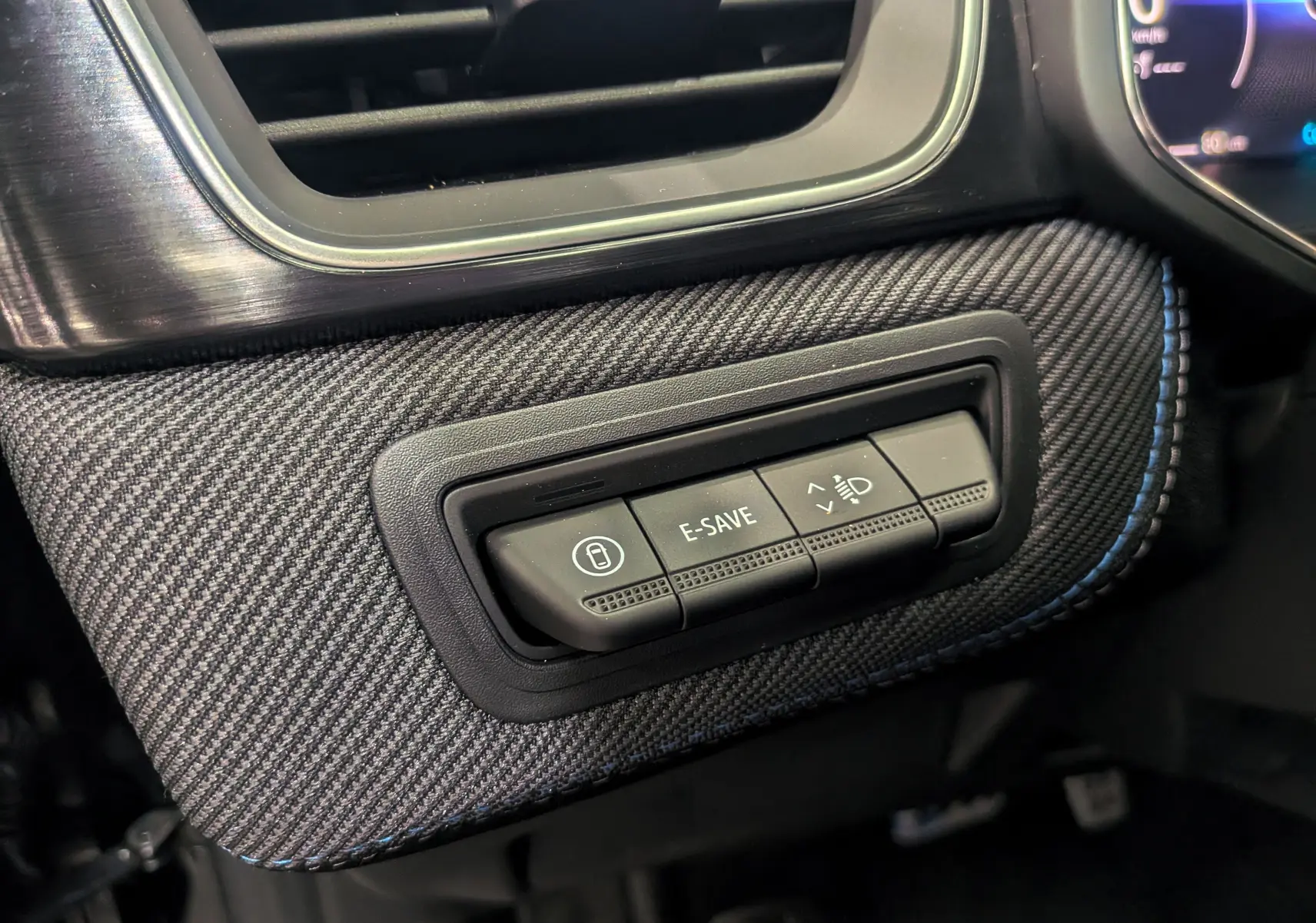 Gros plan sur les commandes E-SAVE et réglage des phares dans l'habitacle du Renault Captur noir étoilé 2025 esprit Alpine.