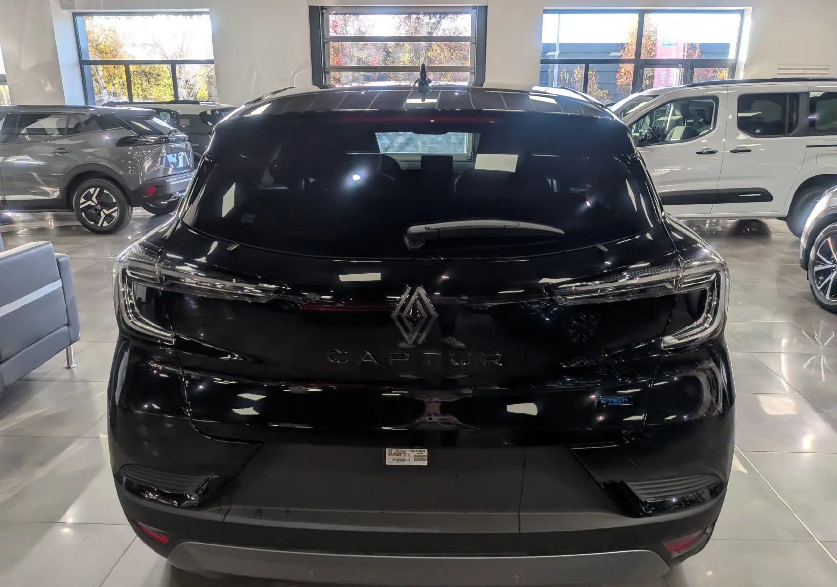 Vue arrière d'un Renault Captur E-TECH Full Hybrid 2025 noir étoilé avec feux LED et logo central lumineux.