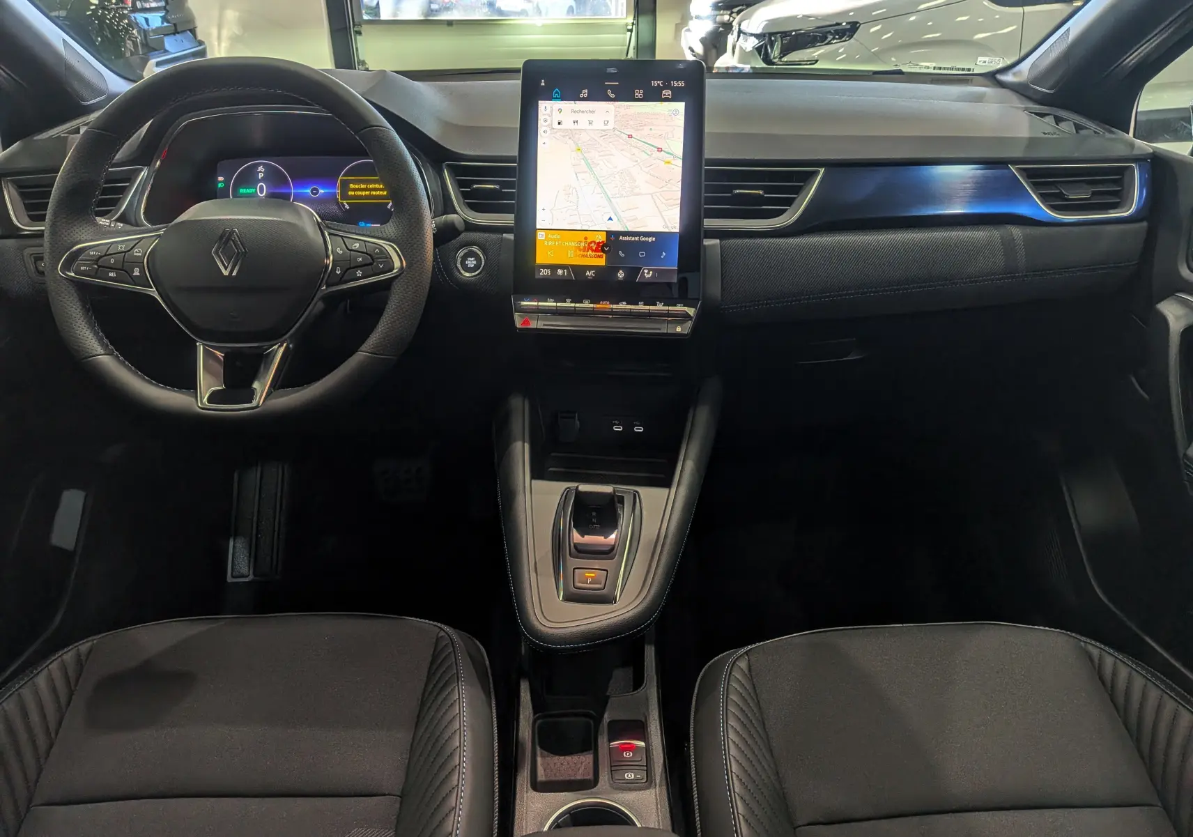 Vue intérieure du tableau de bord et volant du Renault Captur E-TECH 2025 avec écran tactile central et sellerie noire.
