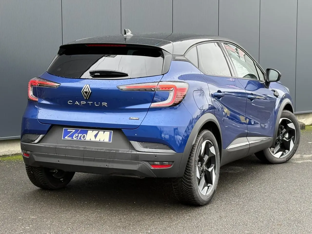 Vue 3/4 arrière droite du Renault Captur bleu Iron avec toit noir et jantes aluminium 18 pouces Black Hole.