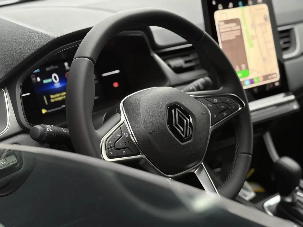 Vue rapprochée du volant noir et du tableau de bord digital du Renault Captur 2025 avec écran tactile vertical.