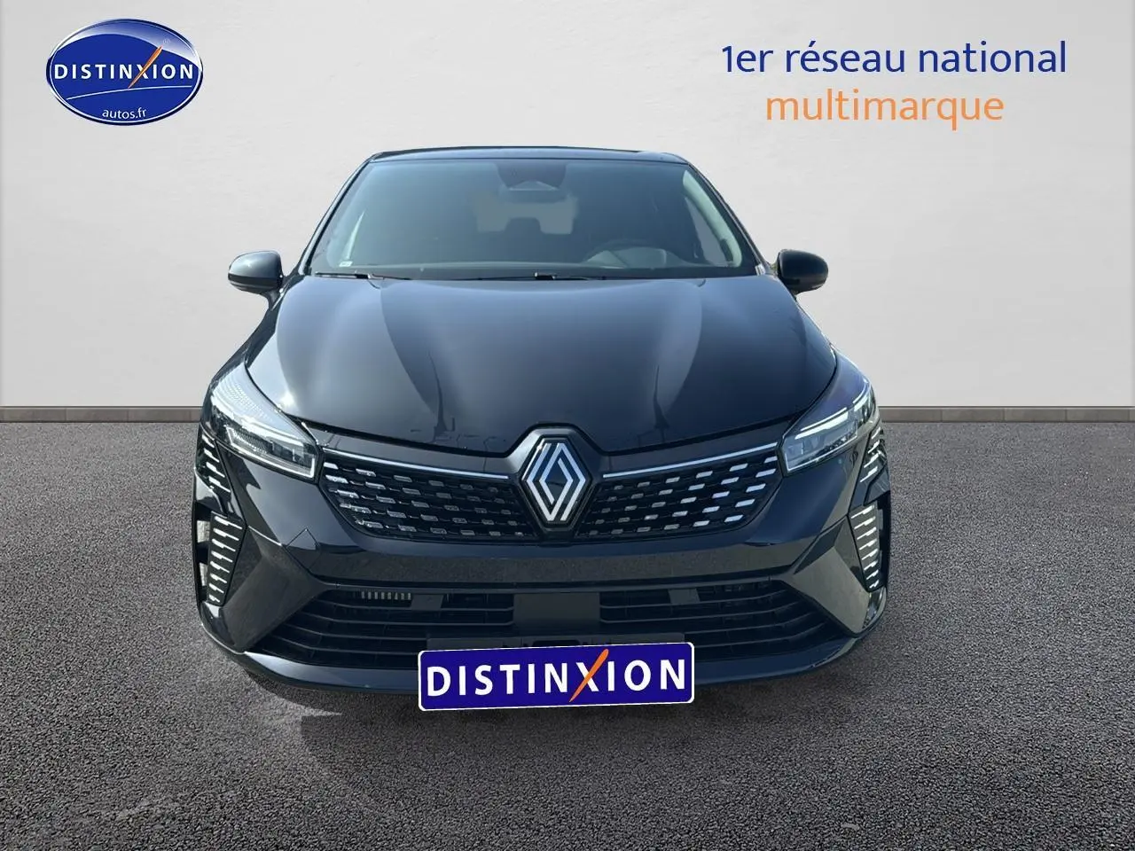 Vue avant d'une Renault Clio V noire avec calandre chromée et phares LED distinctifs sur fond neutre.