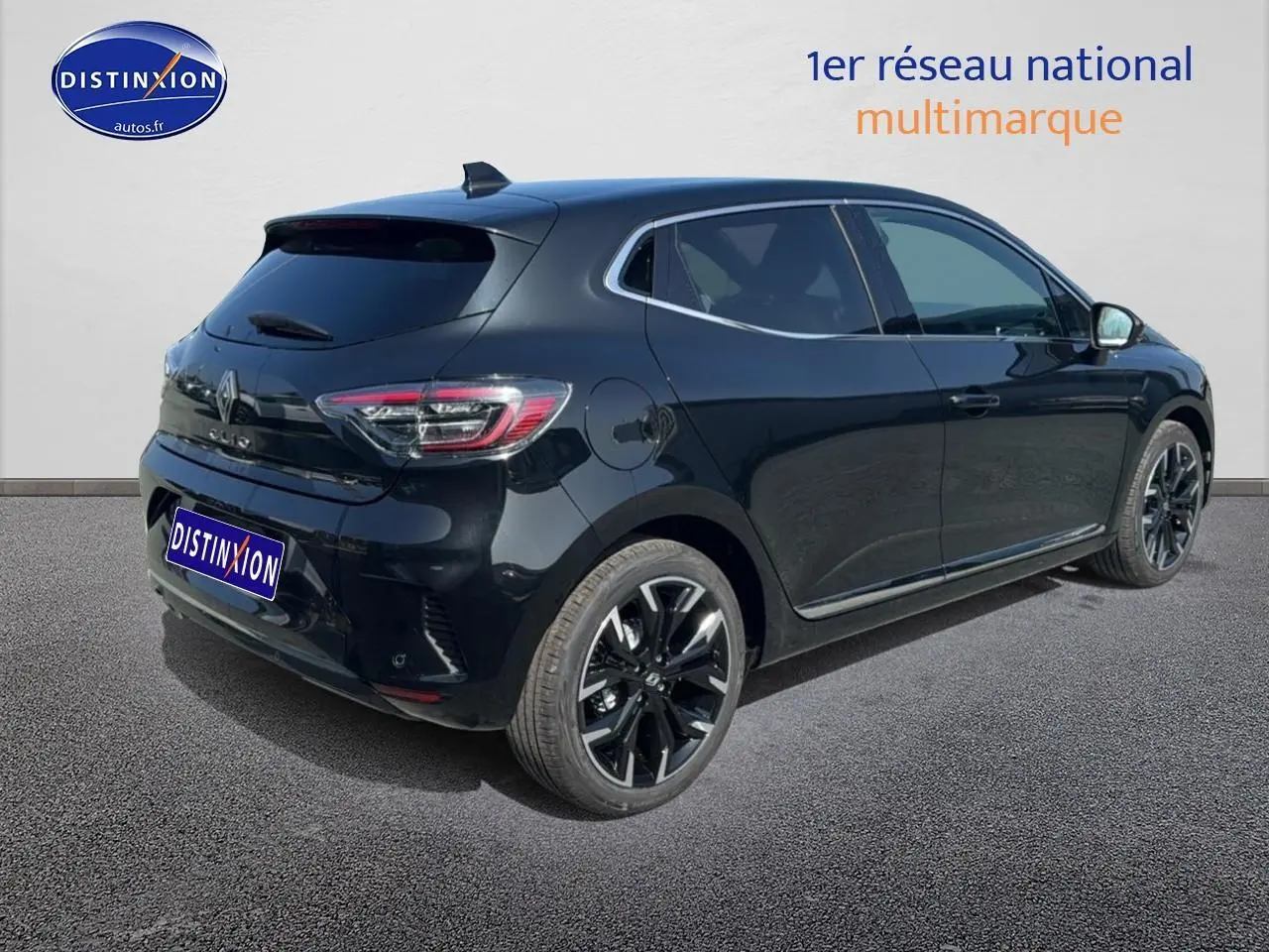 Renault Clio V noire vue 3/4 arrière droit, jantes alliage noires et becquet arrière distinctif.