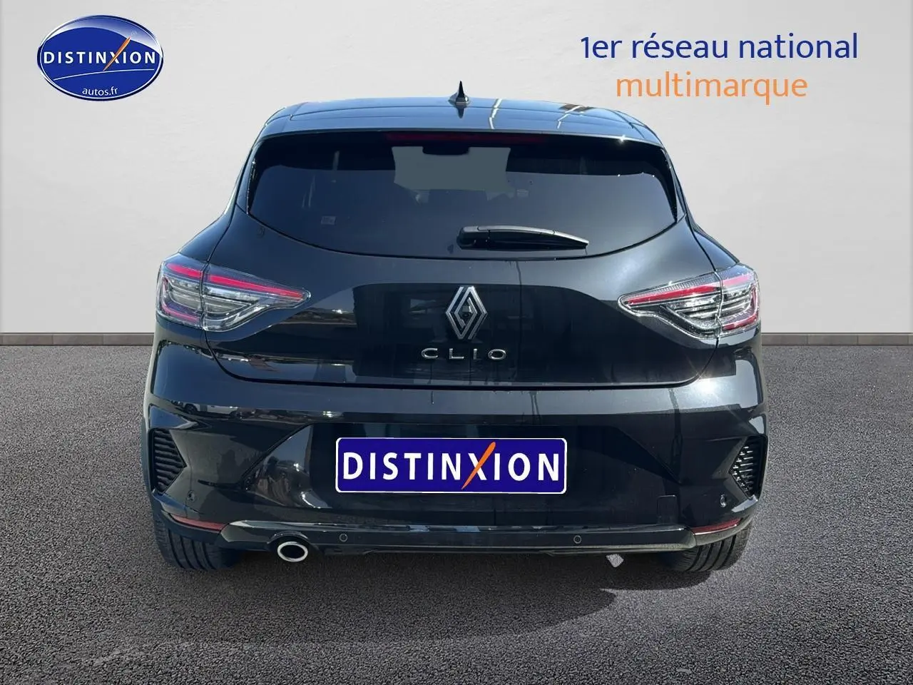 Vue arrière d'une Renault Clio V noire avec feux LED et sortie d'échappement chromée sur sol gris.