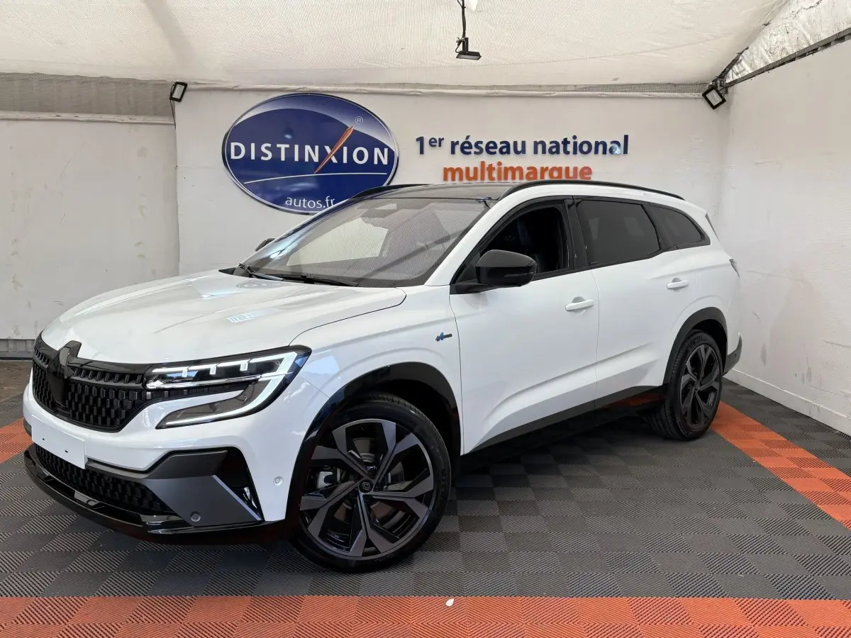 Renault Espace Esprit Alpine blanc en 3/4 avant droit, avec jantes noires et toit panoramique visible.