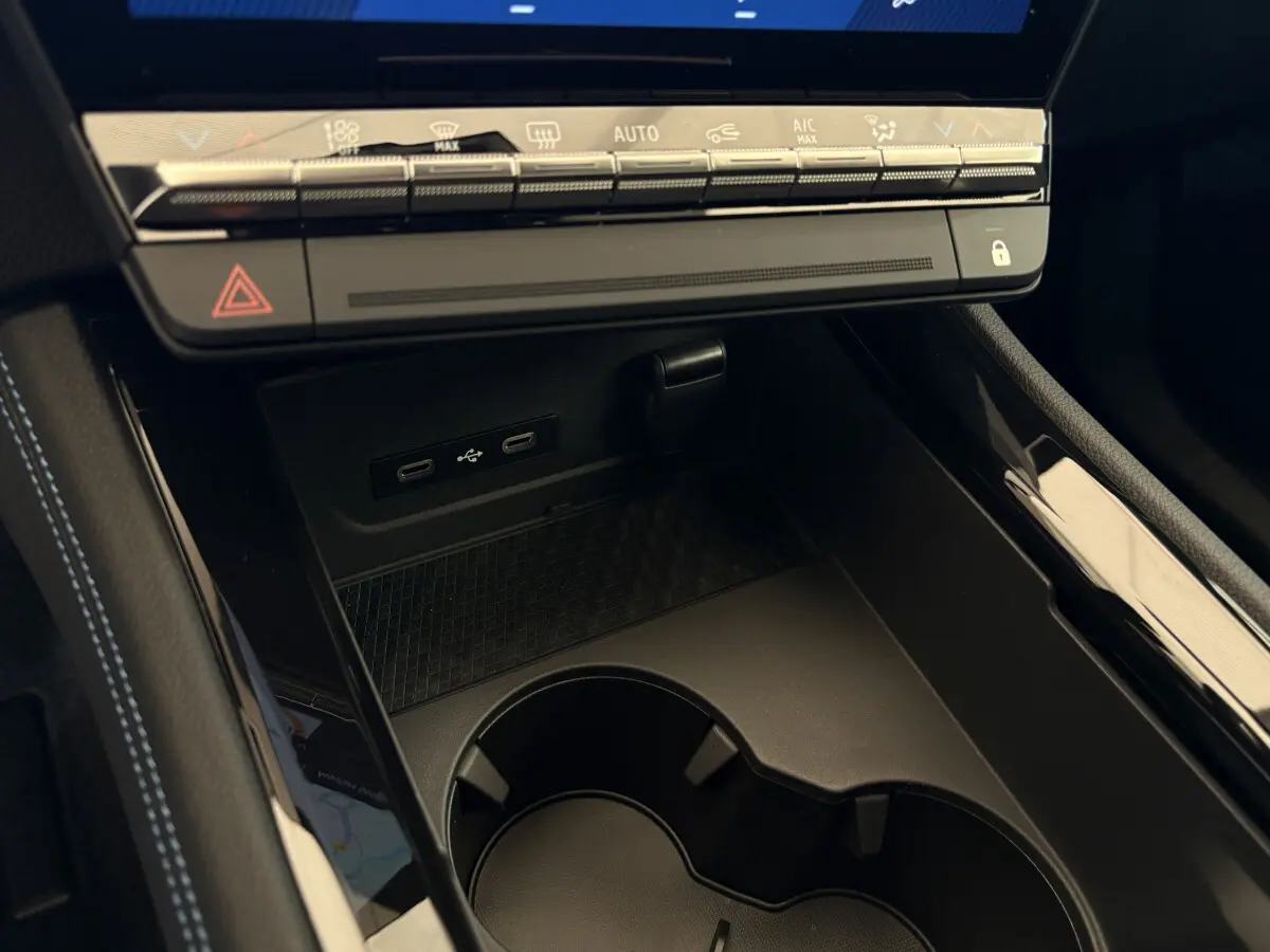 Gros plan sur la console centrale noire du Renault Espace 2025, avec ports USB-C et commandes tactiles de climatisation.