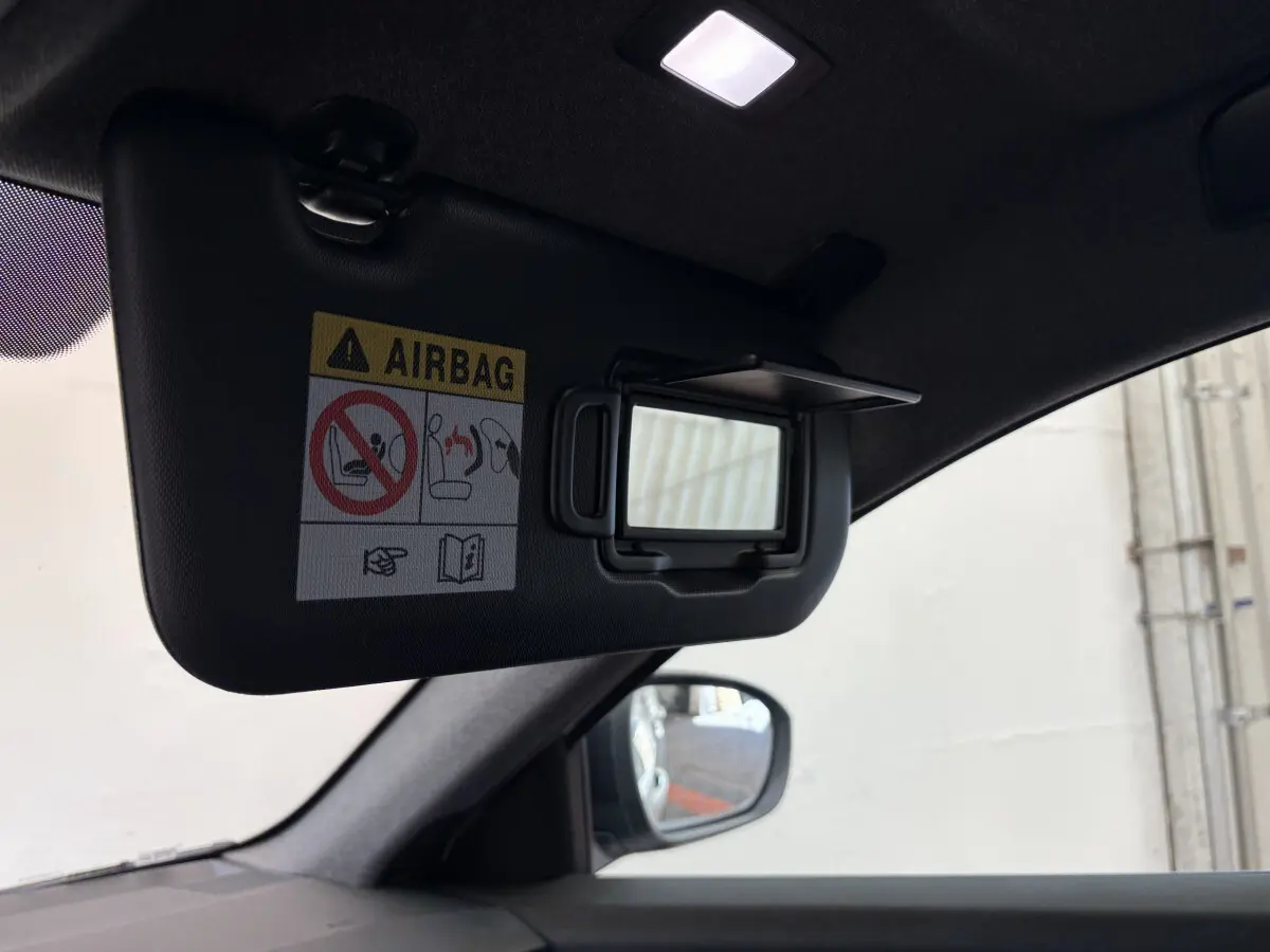 Détail intérieur du pare-soleil côté conducteur avec miroir et avertissement airbag dans un Renault Espace blanc 2025.