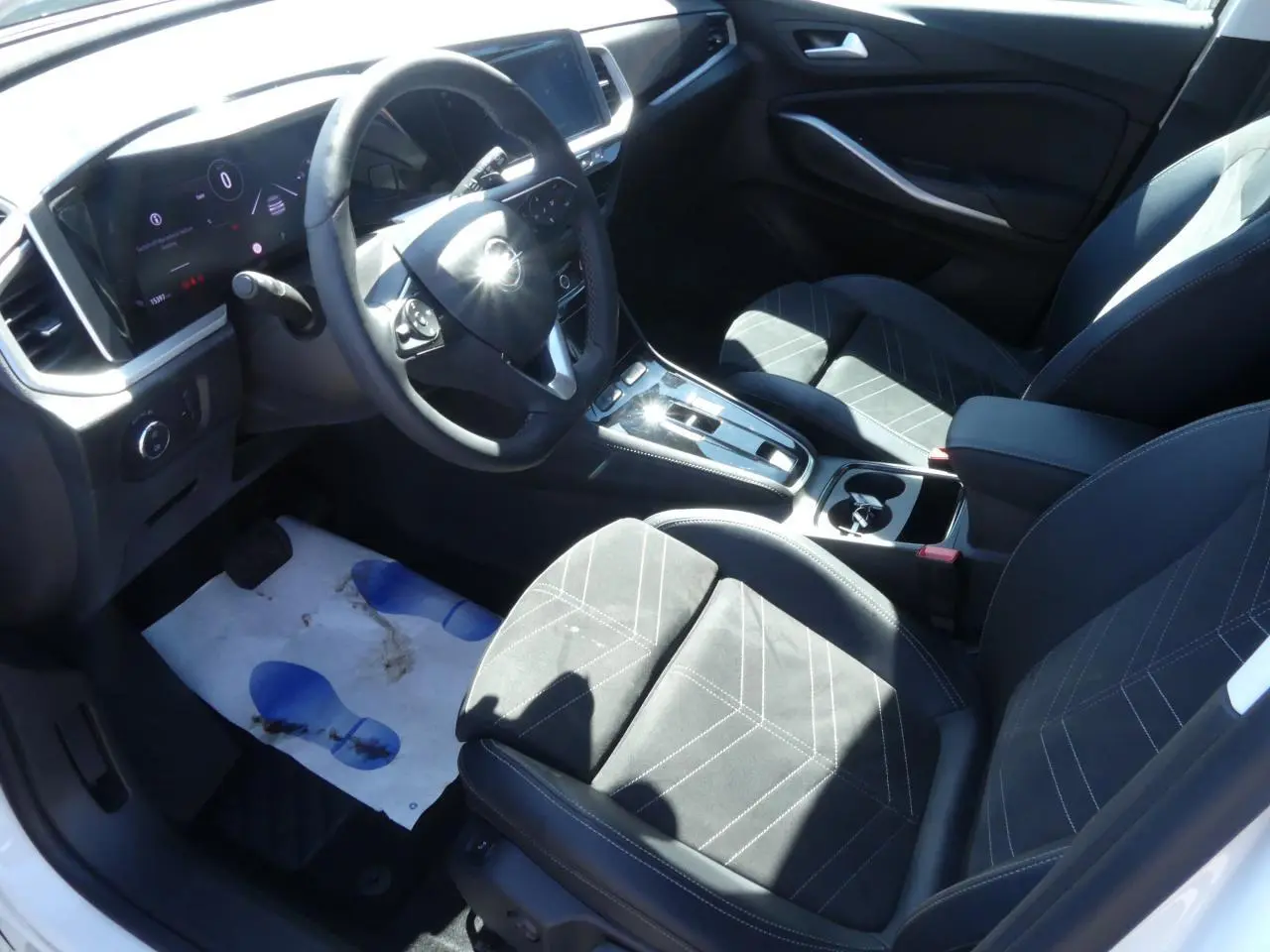 Intérieur de l’Opel Grandland 2024 vu côté conducteur, sellerie Alcantara noire avec coutures blanches et console centrale moderne.