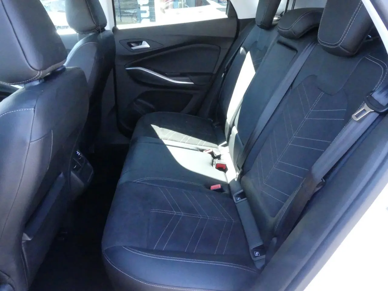 Vue intérieure côté droit sur la banquette arrière en Alcantara noir avec surpiqûres blanches de l'Opel Grandland 2024.